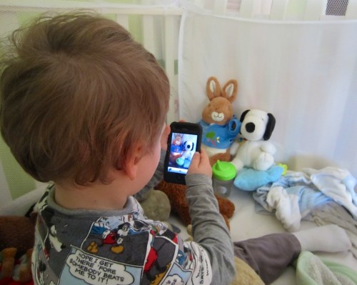 “Say Cheese!” My son works the moment in his crib photographing his favorite animals!