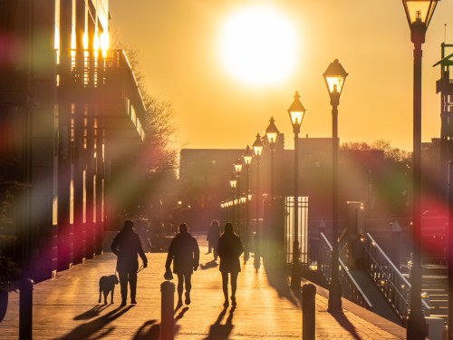People walking in Baltimore's Harbor East neighborhood at sunrise